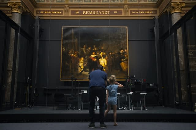 A limited amount of visitors admire Rembrandt’s Night Watch  (Peter Dejong/AP)