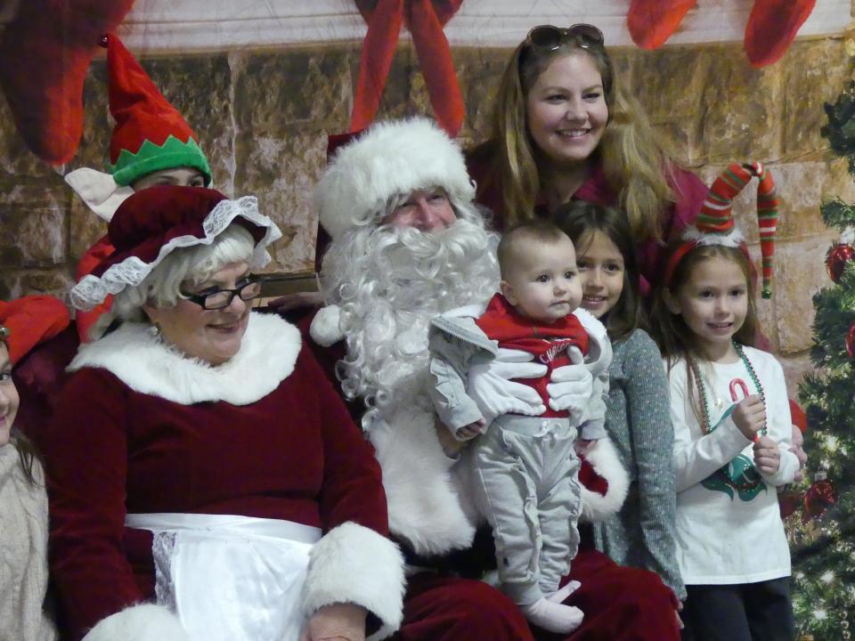 A family visits with Mr. and Mrs. Santa Claus during the 19th annual Doris Davies Memorial Bicycle Giveaway on Wednesday at the San Bernardino County Fairgrounds in Victorville.
