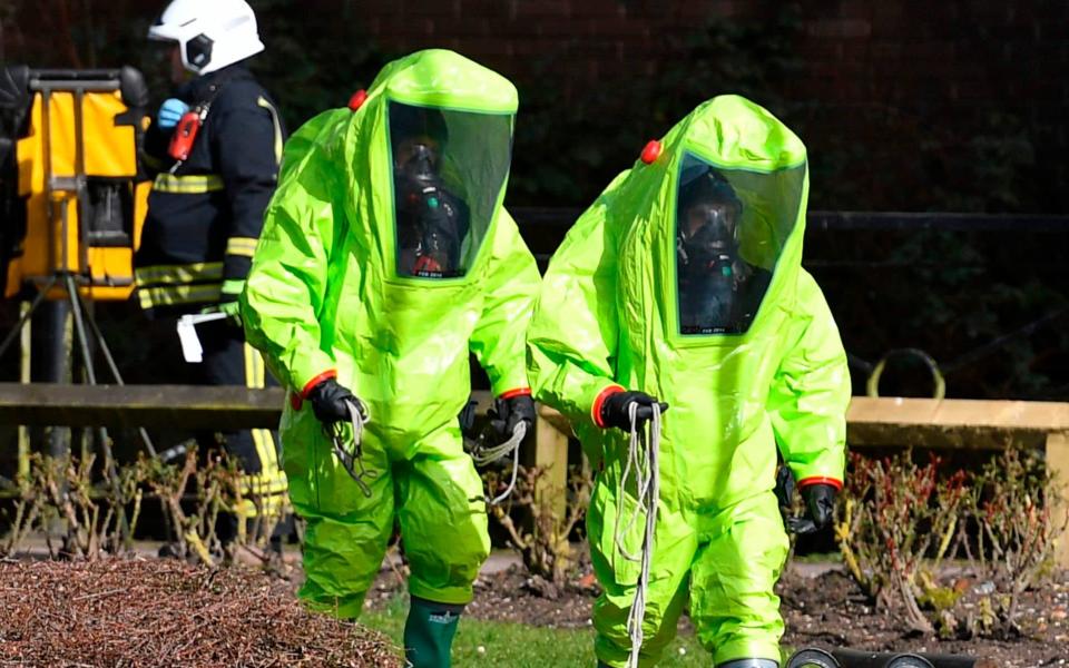 FILES) In this file photo taken on March 08, 2018 members of the fire brigade in green biohazard encapsulated suits work to re-attach the tent at the scene of a nerve agent attack at The Maltings shopping centre in Salisbury, southern England. - The English town of Salisbury is officially decontaminated, the government said Friday, almost a year after it was the scene of a nerve agent attack on Russian ex-spy Sergei Skripal.  - Ben STANSALL/AFP/Getty Images