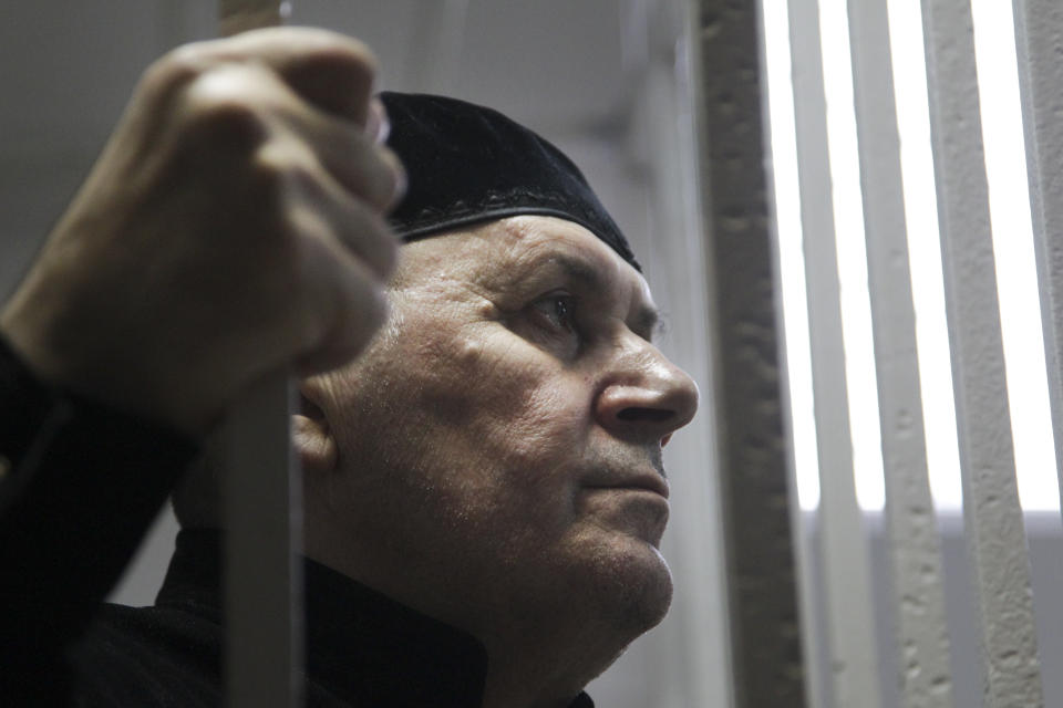 Oyub Titiev, the head of a Chechnya branch of the prominent human rights group Memorial, stands behind bars in court before a hearing in Shali, Russia, Monday, March 18, 2019. Oyub Titiyev was detained in January 2018 and charged with drug possession in what has been largely perceived as a vendetta against this rare critic of the Chechen government. The court is due to issue its verdict Monday. (AP Photo/Musa Sadulayev)