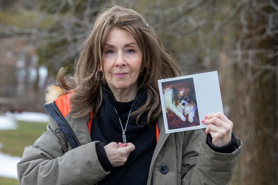 Rhonda Bomwell, of Somerset, N.J., holds a necklace with her dog's ashes and a photograph of her 9-year-old Papillon, Pierre, that died June 1, 2020, because of side effects from wearing a popular flea and tick collar for pets. Bomwell, seen Monday, March 1, 2021, had never used a collar on Pierre because he was mostly an indoor animal.