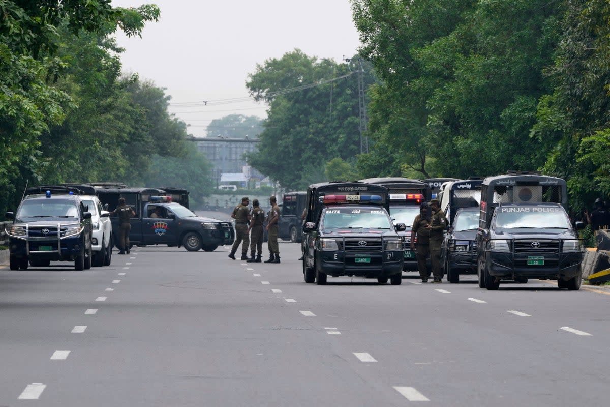 Police officers prepare to take position at a road leading to the residence of Pakistan’s former prime minister Imran Khan  (Associated Press)