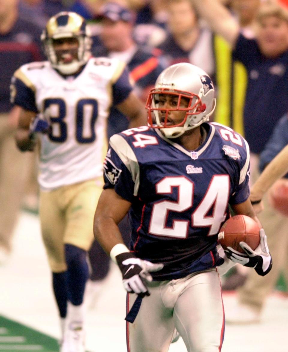 New England Patriots cornerback Ty Law (24) is trailed by St. Louis Rams' Isaac Bruce (80) as he scores a touchdown on an interception return during the second quarter of Super Bowl XXXVI at the Louisiana Superdome on Feb. 3, 2002, in New Orleans.