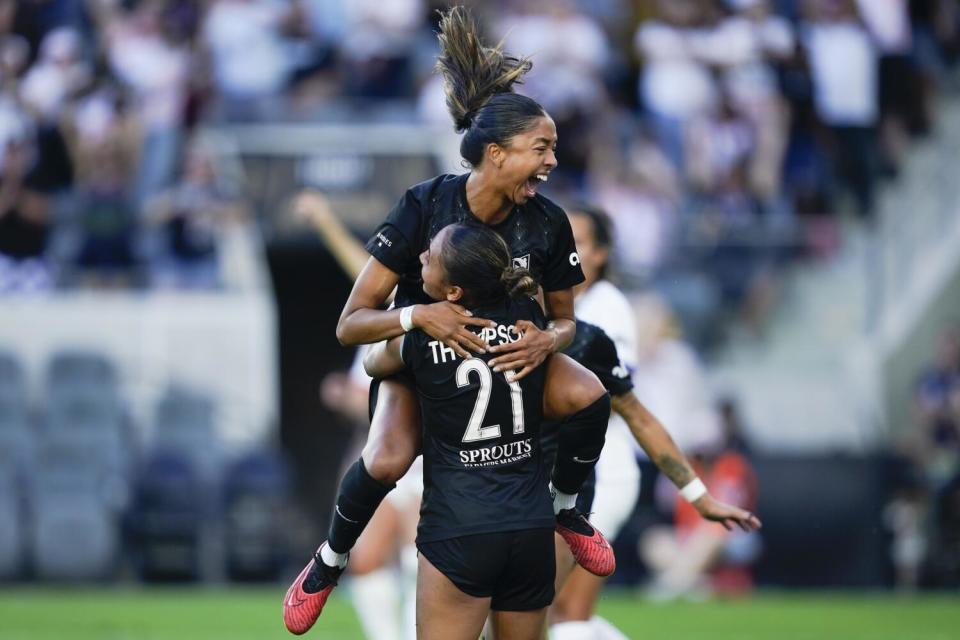 Angel City defender Madison Hammond, top, celebrates with teammate Alyssa Thompson after scoring against the OL Reign.