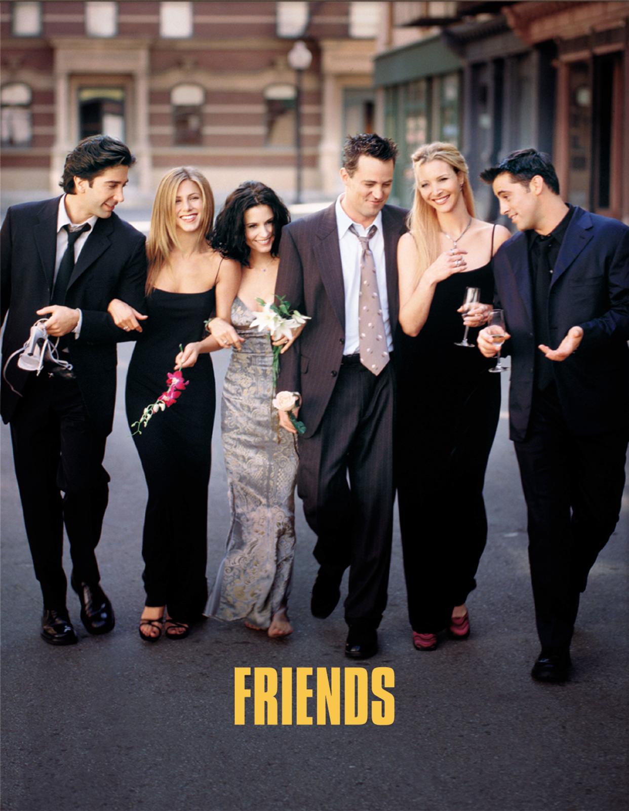 The cast of 'Friends' wears formal wear walking down an NYC street. 'Friends' is written at the bottom in yellow