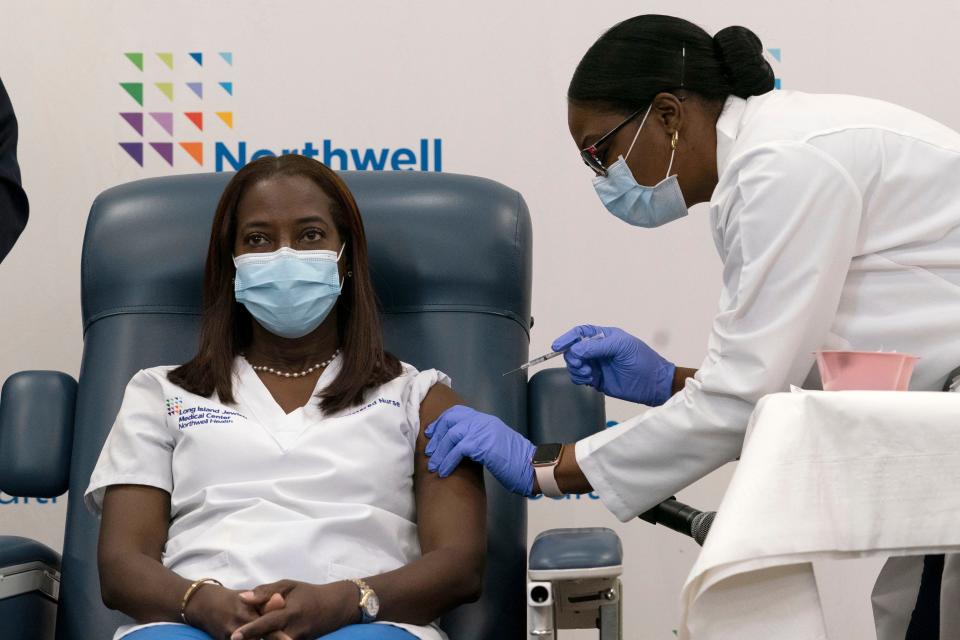 Sandra Lindsay, left, a nurse at Long Island Jewish Medical Center, is inoculated with the Pfizer-BioNTech COVID-19 vaccine by Dr. Michelle Chester, Monday, Dec. 14, 2020, in New York.