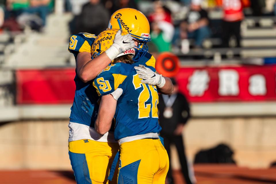 San Juan High School’s Taeg Palmer, left, hugs teammate Zack Conway after his carry for the two-point conversion during the 2A football state championship game against South Summit at Southern Utah University in Cedar City on Saturday, Nov. 11, 2023. | Megan Nielsen, Deseret News