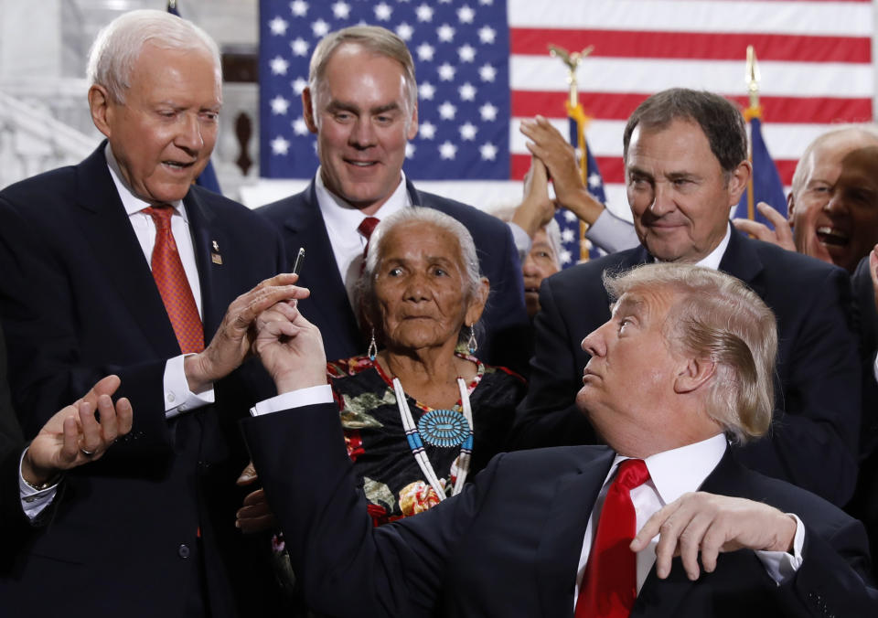 <span class="s1">President Trump hands a pen used to sign an executive order to Sen. Orrin Hatch, R-Utah, after announcing big cuts to Utah’s sprawling wilderness national monuments on Dec. 4, 2017. Among those looking on are Interior Secretary Ryan Zinke and Rep. Mike Lee, R-Utah. (Photo: Kevin Lamarque/Reuters)</span>