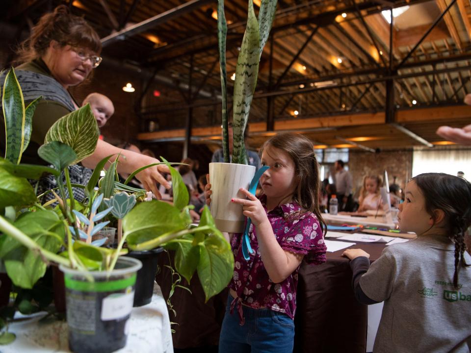 Grace Cobb handles a snake plant she helped grow for the fair.