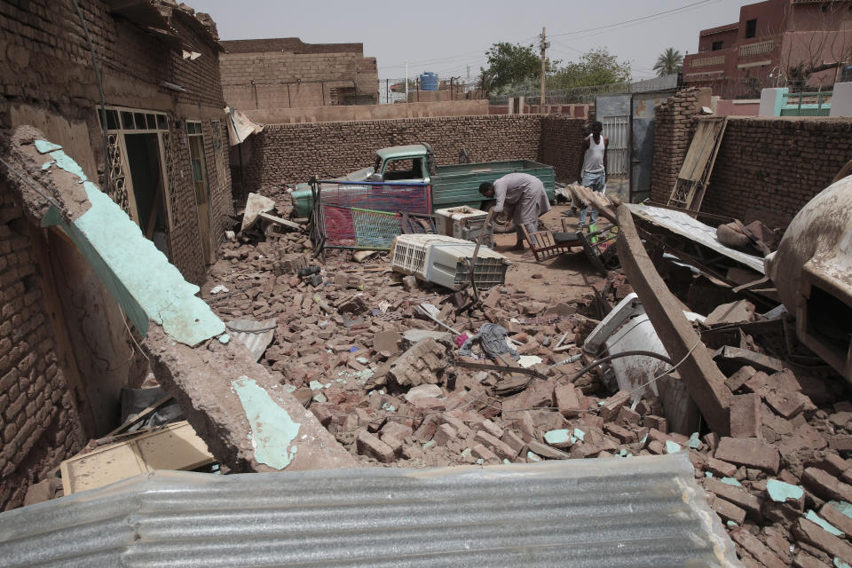 FILE - A man cleans debris of a house hit in recent fighting in Khartoum, Sudan, on April 25, 2023. In the country's capital, Sudan's army and the paramilitary group known as the Rapid Support Forces have battled in the streets with automatic rifles, artillery and airstrikes. An AP journalist, waiting for a chance to leave the country, sheltered with a diverse group of more than a dozen people who hunkered down in a small hotel in central Khartoum. (AP Photo/Marwan Ali, File)