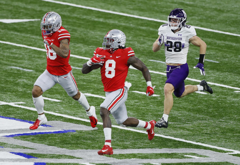 Dec 19, 2020; Indianapolis, IN, USA; Ohio State Buckeyes running back Trey Sermon (8) rushes for 65 yards ahead of wide receiver Kamryn Babb (18) and Northwestern Wildcats linebacker Chris Bergin (28) during the third quarter of the Big Ten Championship football game at Lucas Oil Stadium in Indianapolis on Saturday, Dec. 19, 2020. Ohio State won 22-10. Mandatory Credit: Joshua A. Bickel-USA TODAY NETWORK