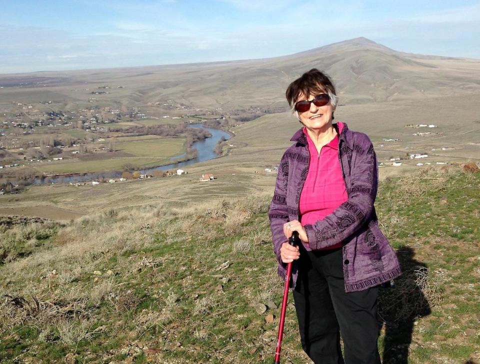 Sharon Grant, co-founder of Friends of Badger Mountain, was named the 52nd Tri-Citian of the Year for 2024. In this file photo, she pauses on the west end of Red Mountain with the Yakima River and Rattlesnake Mountain visible in the background. Courtesy Sharon Grant