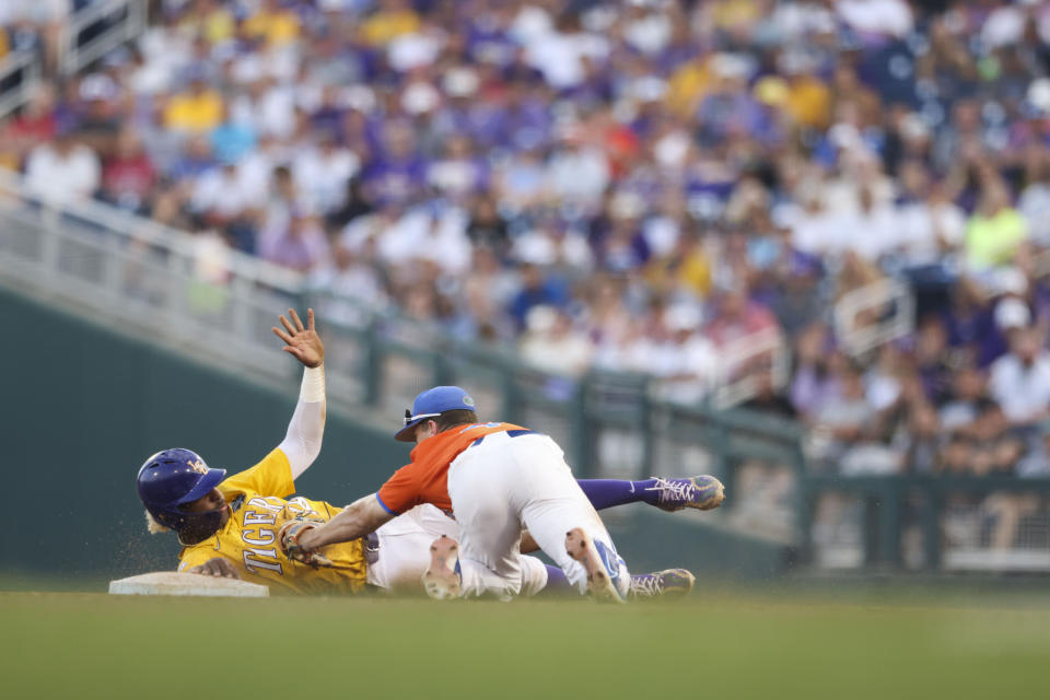 LSU's Tre' Morgan avoids the tag by Florida infielder Cade Kurland (4) at second base in the seventh inning of Game 3 of the NCAA College World Series baseball finals in Omaha, Neb., Monday, June 26, 2023. (AP Photo/Rebecca S. Gratz)