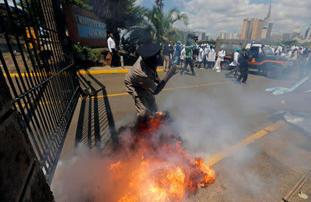 A tear gas canister fired by riot police explodes near a policeman as the police disperse doctors striking to demand fulfilment of a 2013 agreement between their union and the government that would raise their pay and improve working conditions outside Ministry of Health headquarters in Nairobi, Kenya December 5, 2016. REUTERS/Thomas Mukoya