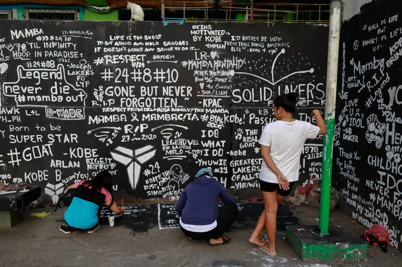 Fans write messages in memory of Kobe Bryant after he and his daughter Gianna died in a helicopter crash, on the basketball court of a housing tenement in Taguig City, Metro Manila