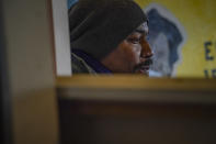 Painter Guy Stanley Philoche, a 43-year-old Haitian immigrant and star in the New York art world, sit among work during an interview at his East Harlem studio, Thursday Nov. 19, 2020, in New York. After a hugely successful gallery show, Philoche wanted to treat himself to a fancy $15,000 watch, instead he bought the works of fellow artists struggling in the pandemic. "I'm not a rich man," he said, "but I owe a big debt to the art world." (AP Photo/Bebeto Matthews)