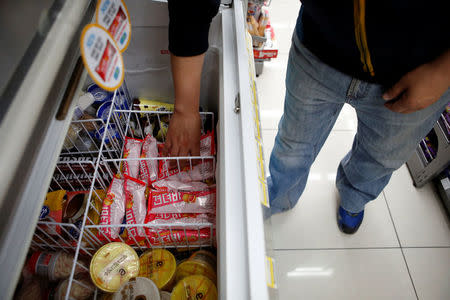 A clerk arranges ice cream bars named Gyeondyo-bar, which translates to "hang in there" at a convenience store in Seoul, South Korea, May 20, 2016. REUTERS/Kim Hong-Ji