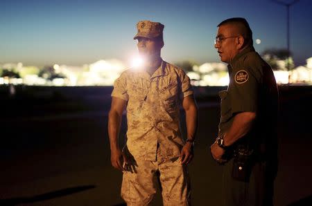First Lt. Jose Negrete (L) and a border patrol agent speak with residents at the scene of a U.S. military jet crash in Imperial, California June 4, 2014. REUTERS/Sandy Huffaker