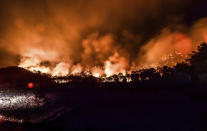 Advancing fires rage the Hisaronu area, Turkey, late Monday, Aug. 2, 2021. For the sixth straight day, Turkish firefighters battled Monday to control the blazes that are tearing through forests near Turkey's beach destinations. Fed by strong winds and scorching temperatures, the fires that began Wednesday have left eight people dead. Residents and tourists have fled vacation resorts in flotillas of small boats or convoys of cars and trucks. (AP Photo)