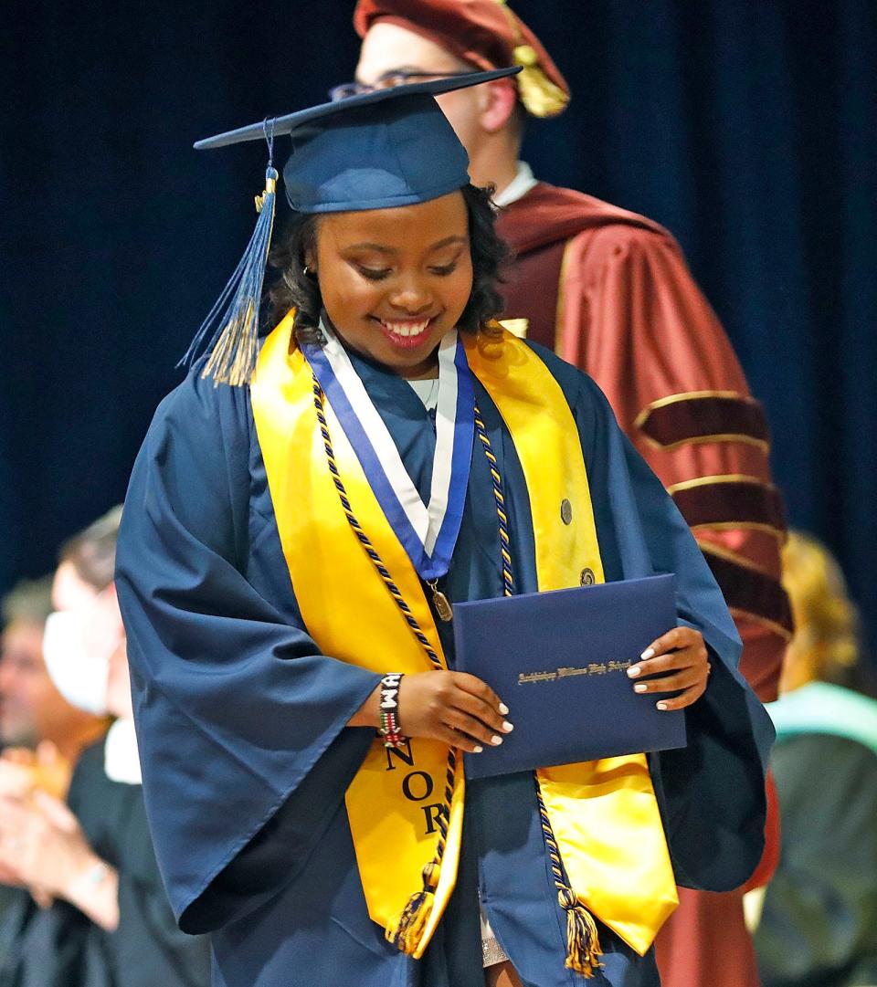 Tracey Maina wears a smile after receiving her diploma at Archbishop Williams High School in Braintree 70th commencement on Thursday, May 26, 2022.