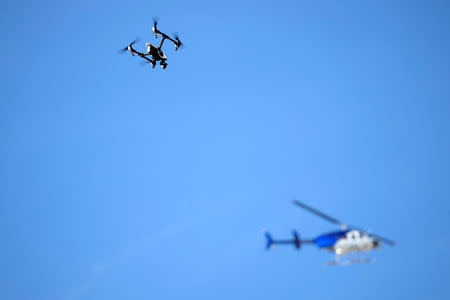 A news helicopter flies overhead as a firefighting drone hovers above a warehouse where a fire broke out during an electronic dance party late Friday evening, resulting in at least nine deaths and many unaccounted for in the Fruitvale district of Oakland, California, U.S. December 3, 2016. REUTERS/Stephen Lam