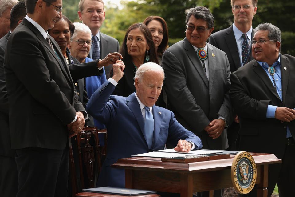 President Joe Biden gives away pens he used to sign proclamations expanding the areas of three national monuments at the White House on Oct. 8, 2021. Biden restored the areas of two Utah parks with lands held sacred by several Native American tribes.