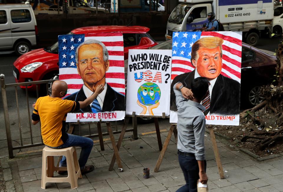 Indian art teacher Sagar Kambli makes paintings of President Donald Trump and Democratic rival Joe Biden on a pavement outside his art school remaining closed due to the COVID-19 pandemic in Mumbai, India, Thursday, Oct. 29, 2020. (AP Photo/Rajanish Kakade)AP