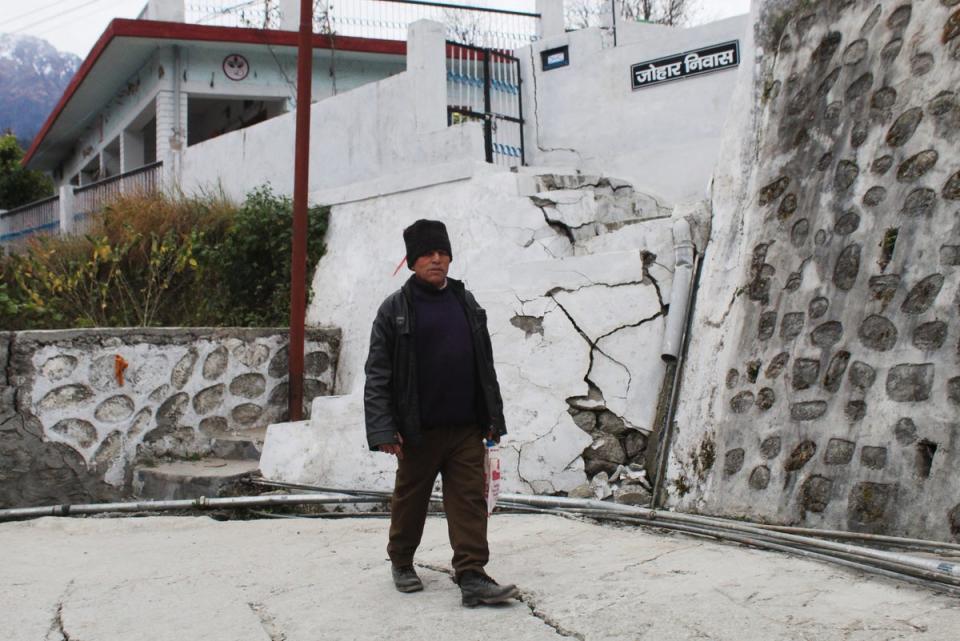 A resident walks past a house damaged with cracks in Joshimath, in Uttarakhand state’s Chamoli district (AFP/Getty)