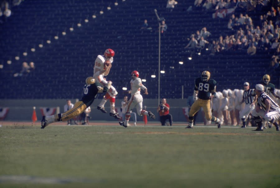 American football player Reg Carolan (center, in white) of the Kansas City Chiefs catches a passes but is tackled by Ray Nitschke of the Green Bay Packers during the first AFL-NFL World Championships (also known as Super Bowl I), Los Angeles, California, January 15, 1967. The Packers went on to win the game 35-10. (Photo by Robert Riger/Getty Images)