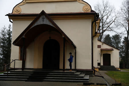 A boy stands outside the church during the mass in Kalinowka, Poland November 25, 2018. REUTERS/Kacper Pempel/Files
