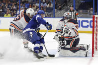 Tampa Bay Lightning's Yanni Gourde crashes the net for a rebound against Edmonton Oilers goaltender Mike Smith as Matt Benning defends during the second period of an NHL hockey game Thursday, Feb. 13, 2020, in Tampa, Fla. (AP Photo/Mike Carlson)