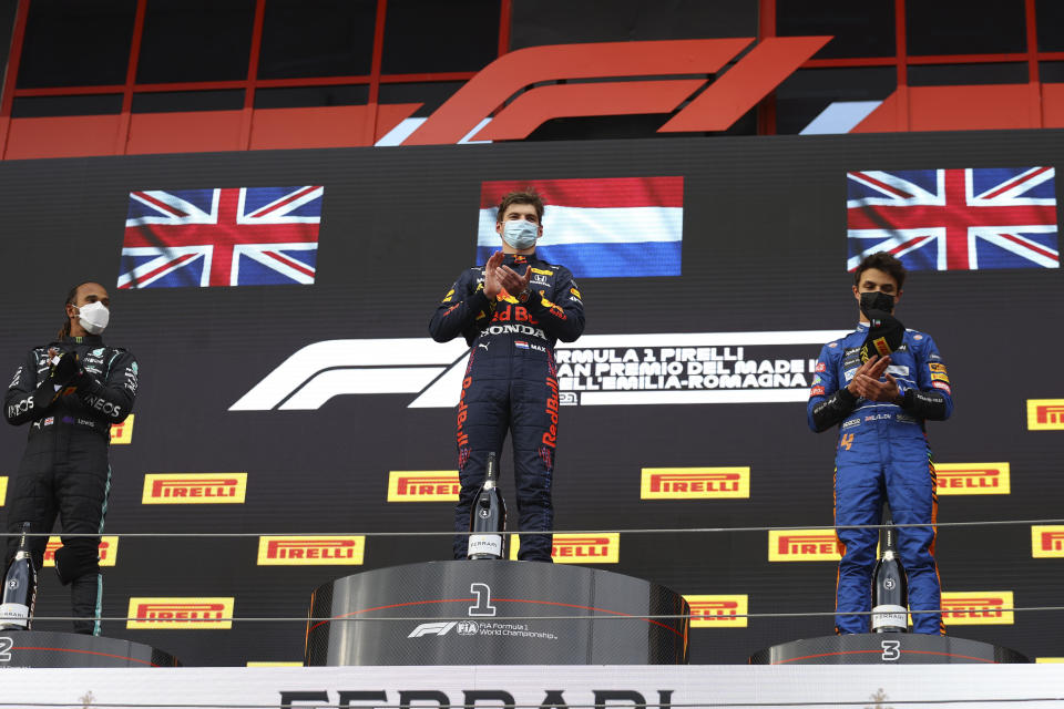 From left, second placed Mercedes Lewis Hamilton, first placed Red Bull's Max Verstappen and third placed McLaren's Lando Norris celebrate on the podium at the end of the Emilia Romagna Formula One Grand Prix, at the Imola racetrack, Italy, Sunday, April 18, 2021. (Bryn Lennon/ Pool Via AP)