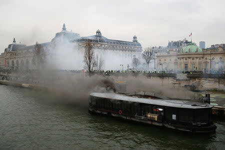 A burning boat moored next to Orsay Museum is seen during a demonstration by the "yellow vests" movement in Paris, France, January 5, 2019. REUTERS/Gonzalo Fuentes