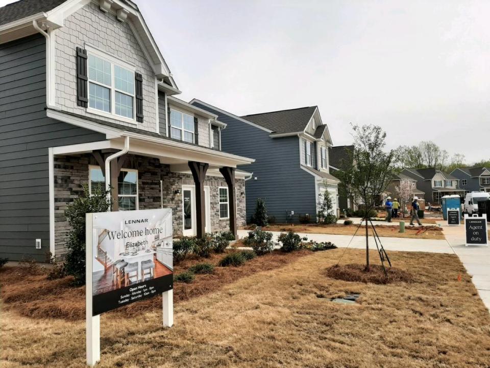 In this 2023 file photo workers go between homes near newly-opened model homes at Elizabeth in Fort Mill. Combined properties in Elizabeth and homes sales elsewhere in the region topped the $1 million mark in January.