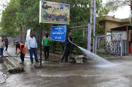 Municipality workers clean the site of a suicide attack in the predominantly Shi'ite Shula district, in northwest Baghdad, Iraq May 24, 2018. REUTERS/Thaier Al-Sudani