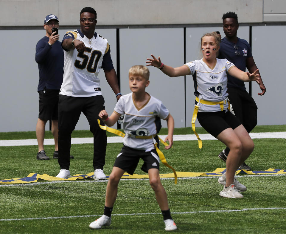 NFL player Samson Ebukam of the Los Angeles Rams coaches a young team during the final tournament for the UK's NFL Flag Championship, featuring qualifying teams from around the country, at the Tottenham Hotspur Stadium in London, Wednesday, July 3, 2019. The new stadium will host its first two NFL London Games later this year when the Chicago Bears face the Oakland Raiders and the Carolina Panthers take on the Tampa Bay Buccaneers. (AP Photo/Frank Augstein)