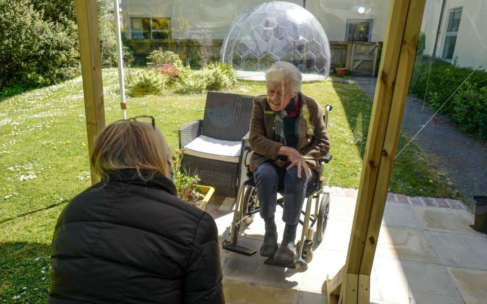  Karen Hastings visits her stepfather Gordon (aged 80), who suffers from dementia, under a temporary open-air shelter with a clear screen between them, at the Langholme Care Home -  Hugh R Hastings / Getty