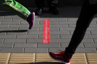 Students walk past a sticker to remind students to keep their social distancing as they arrive for the reopening of a primary school in Beijing, Monday, June 1, 2020. With declining virus case numbers, students have gradually returning to their classes in the capital city. (AP Photo/Andy Wong)