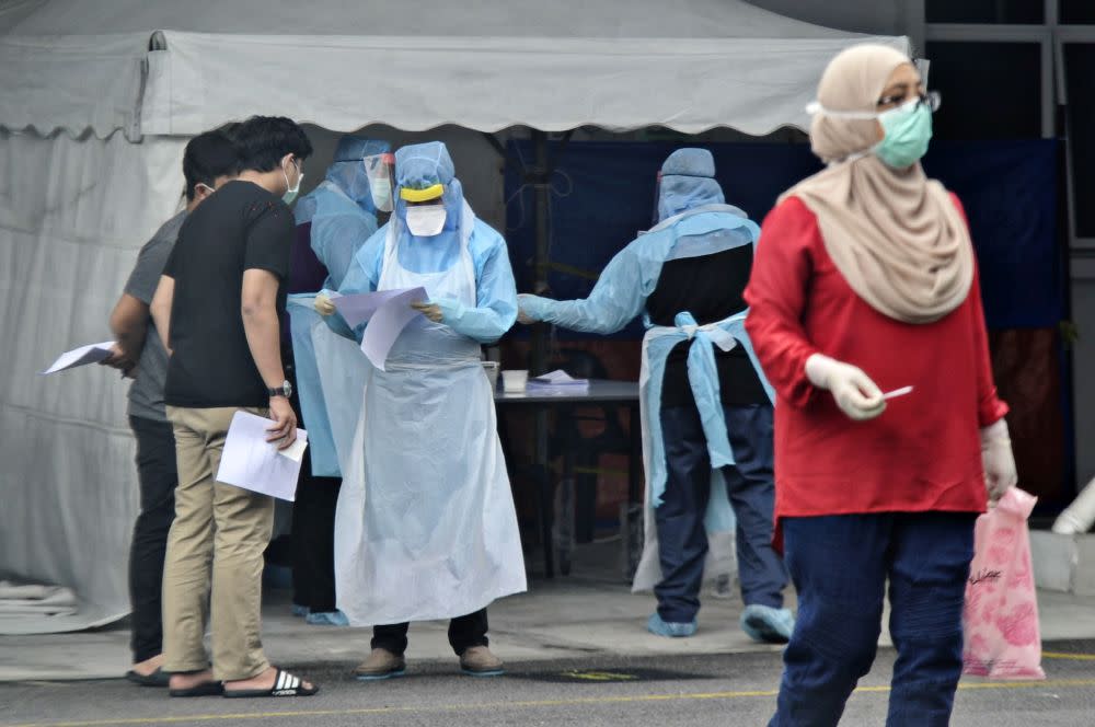 Government health workers attend to members of the public at the Kuala Lumpur Health Clinic March 24, 2020. — Picture by Shafwan Zaidon