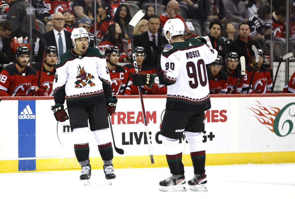 Arizona Coyotes defenseman Matt Dumba (24) celebrates with J.J. Moser (90) after Dumba scored a goal against the New Jersey Devils during the first period of an NHL hockey game Friday, Oct. 13, 2023, in Newark, N.J. (AP Photo/Noah K. Murray)