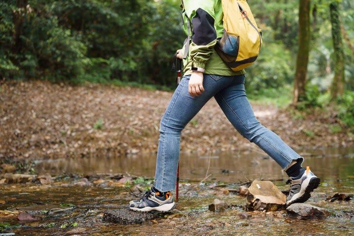 hiker doing a water crossing in jeans