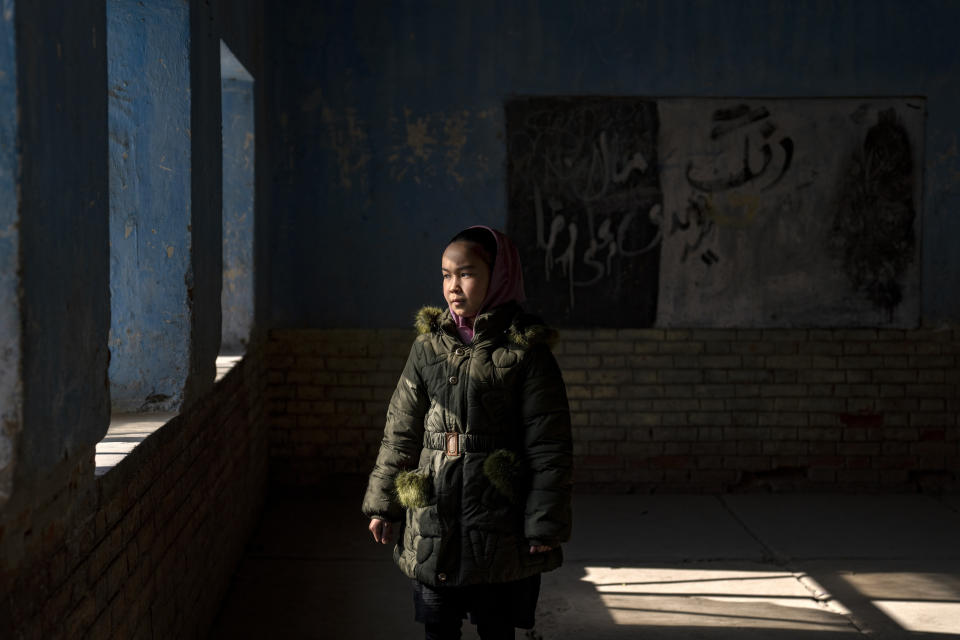 An Afghan schoolgirl poses for a photo in an empty classroom in Kabul, Afghanistan, Thursday, Dec. 22, 2022. The country's Taliban rulers earlier this week ordered women nationwide to stop attending private and public universities effective immediately and until further notice. They have banned girls from middle school and high school, barred women from most fields of employment and ordered them to wear head-to-toe clothing in public. Women are also banned from parks and gyms.(AP Photo/Ebrahim Noroozi)