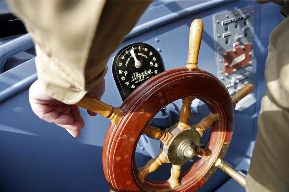 CORRECTS BOAT NUMBER TO 305, NOT 105 - Capt. George Benedetto steers during a media ride Thursday, March 16, 2017, on the PT 305, which was restored by the National WWII Museum, on Lake Pontchartrain, where she was originally tested by Higgins Industries more than 70 years ago, in New Orleans. The U.S. Navy PT boat that sank three vessels and saw action in Europe in World War II is back in New Orleans where it was built, what historians describe as the nation's only fully restored combat ship of that type from the era. Its return to water is the culmination of a 10-year restoration project by the museum. (AP Photo/Gerald Herbert)