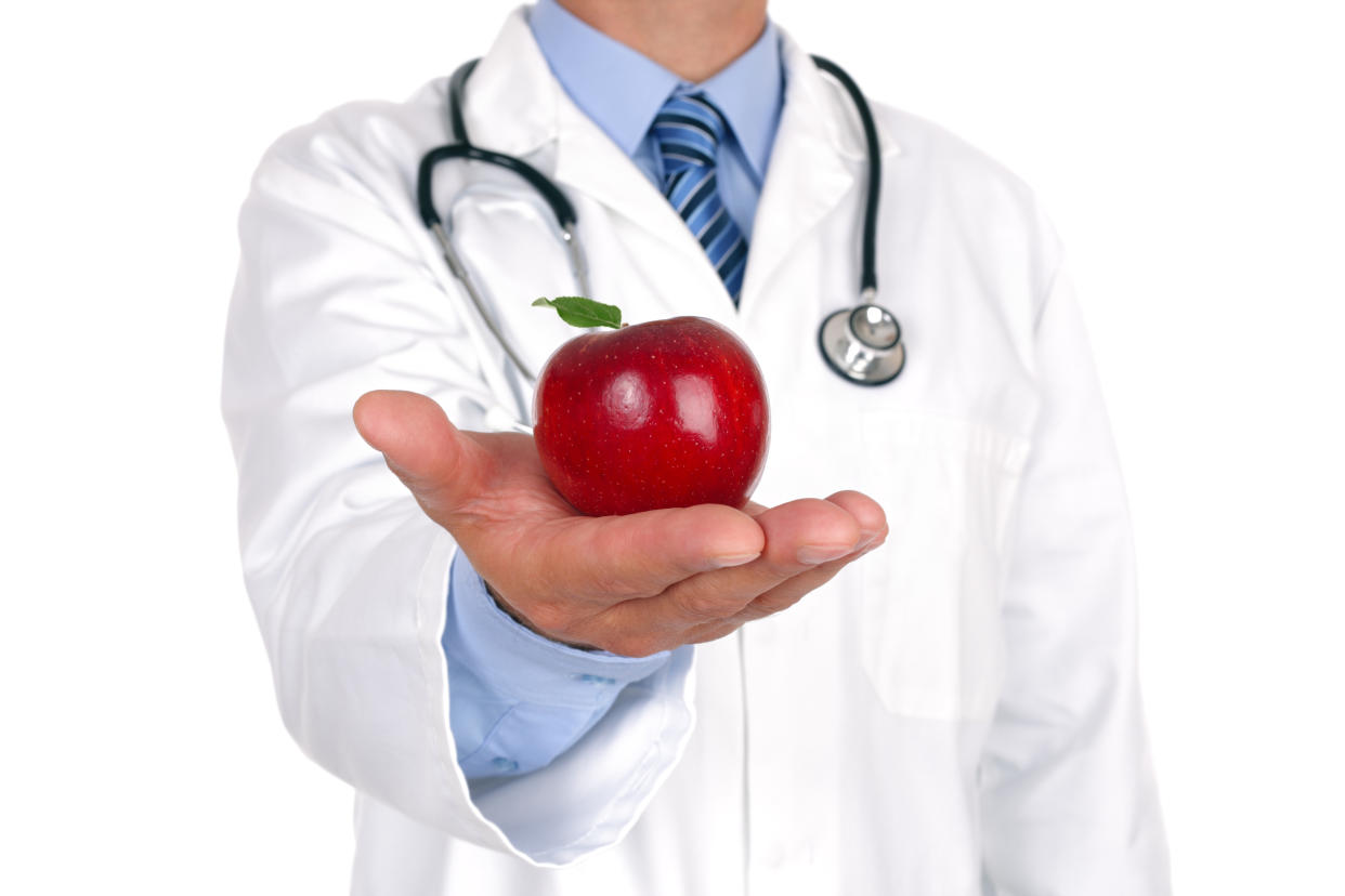 Doctor giving apple concept for healthy eating and lifestyle or good diet