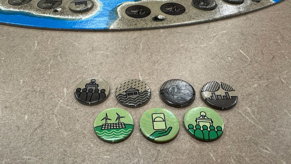 Event markers in Catan: New Energies determine positive or negative in-game effects. The brown markers, from left, depict a climate conference, rain and flooding, environmental pollution, and air pollution. - Courtesy CATAN GmbH