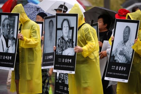 People march holding portraits of deceased victims of wartime forced labor during the Japanese colonial period, during an anti-Japan protest on Liberation Day in Seoul