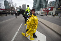 <p>A police officer smiles as he walks off with used police tape after the partial opening of Yonge Street at Finch Avenue April 24, 2016 in Toronto, Canada. (Photo: Cole Burston/Getty Images) </p>