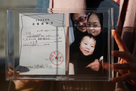 Li Wenzu, the wife of prominent Chinese rights lawyer Wang Quanzhang, holds a box with a family picture and the detention notice for her husband before shaving her head in protest in Beijing, China, December 17, 2018. REUTERS/Thomas Peter/Files