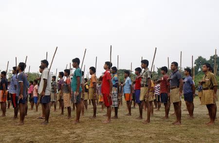 Volunteers of the Hindu nationalist organisation Rashtriya Swayamsevak Sangh (RSS) hold sticks as they pray during a training session at Tatiberia village in West Bengal, India, in this May 20, 2015 file photo. REUTERS/Rupak De Chowdhuri