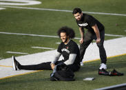 Free agent quarterback Colin Kaepernick, left, stretches before a workout for NFL football scouts and media, Saturday, Nov. 16, 2019, in Riverdale, Ga. (AP Photo/Todd Kirkland)